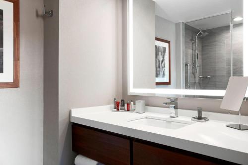 W łazience znajduje się umywalka i lustro. w obiekcie Ithaca Marriott Downtown on the Commons w mieście Ithaca