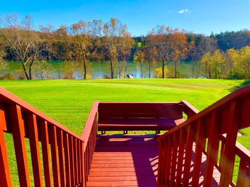 a wooden boardwalk with a bench on a green field at The Barn at Evermore: riverfront retreat w/hot tub in Luray