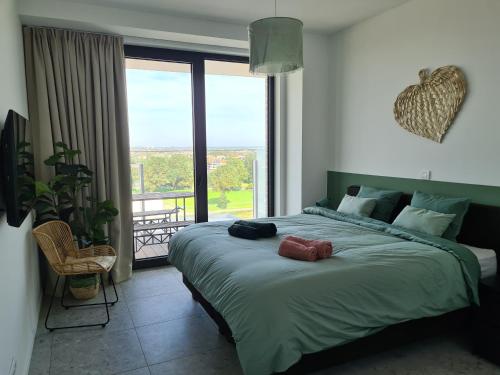 una camera con un grande letto e una grande finestra di Central Park Tower Sea View Residence with pool and gym a Ostenda
