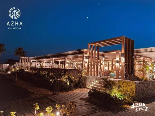 a building with lights in front of it at night at Azha ain sokhna luxury chalet - families only - 155sqm special weekly monthly rates in Ain Sokhna