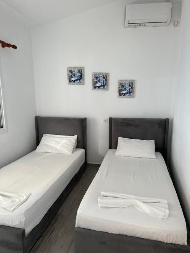 two beds sitting next to each other in a room at Sevilia Rooms in Qeparo