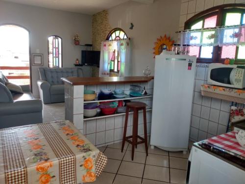 kuchnia z lodówką i stołem w obiekcie Bragança's Houses w mieście Cabo Frio