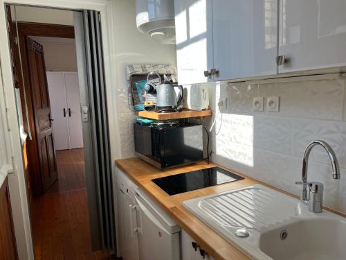 uma cozinha com um lavatório e um micro-ondas em Les Grands Ducs em Trouville-sur-Mer