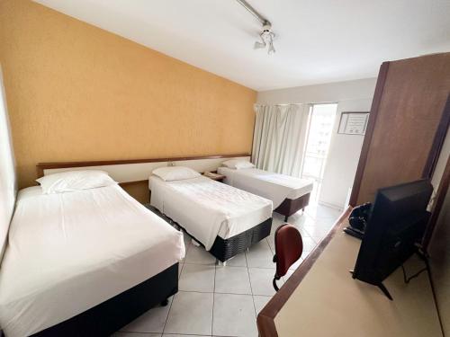 a hotel room with two beds and a television at Apart Hotel em Brasília - Garvey Park Hotel in Brasilia