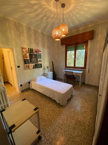 1 dormitorio con cama, mesa y escritorio en Arcobalenotoscano Convivio en Pescia