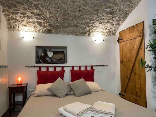 een slaapkamer met een groot bed met rode kussens bij 'Il Caratteristico' (centro storico) in Capistrello