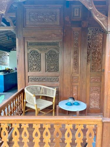 a wooden door with a table and chairs on a porch at Kaiwatu House in Ubud