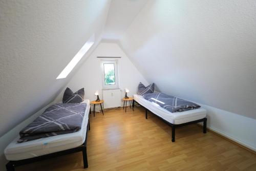 Habitación en el ático con 2 camas y ventana en Ferienwohnung Meerfarbig Zingst - HAUSTIERFREI -Balkon - WLAN - Parkplatz - Fahrradschuppen - zentral&ruhig - E-Ladesäule - Waschtrockner - Nichtraucher, en Zingst