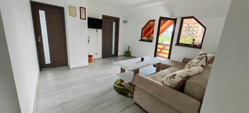 a living room with a couch and a table at Casa Alex in Gălăuţaş