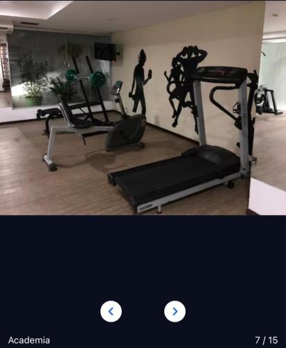 a gym with a treadmill and a woman walking in a room at Flat 406- Imperial Flat Tambaú NOBILE in João Pessoa