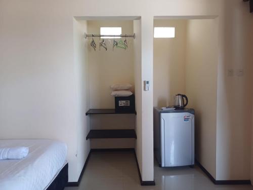 Habitación con cama y nevera pequeña. en melaya beach resort 2, en Penginuman