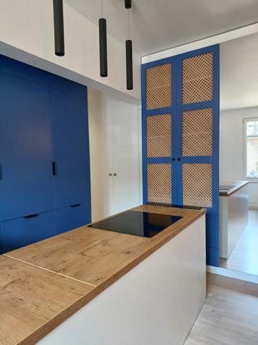 a kitchen with blue cabinets and a counter top at Kowalska no 4 Apartment in Gdańsk