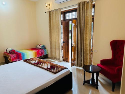 Habitación con cama y silla roja en Bluetique en Varanasi