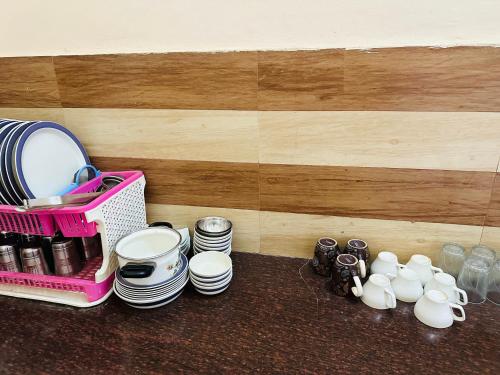 a table with plates and cups and a pink basket at Bluetique in Varanasi