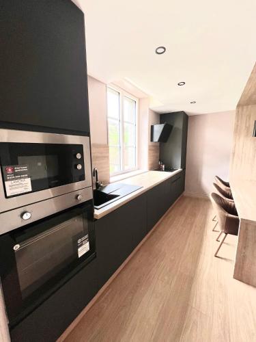 une cuisine avec une cuisinière et un évier dans l'établissement Ma Montagne Chic 3, à La Bresse