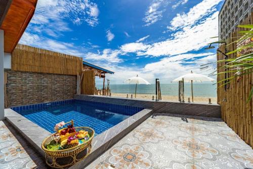 a pool with a bowl of fruit next to the beach at Come Home Beach Villa, 3 Bedrooms CA3 in Ban Huai Sai Tai