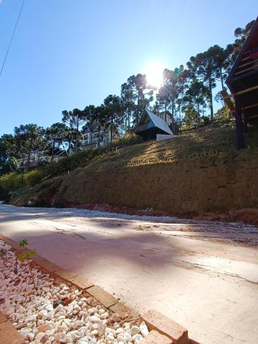 a beach with a house on top of a hill at Chalés Capivari in Campos do Jordão