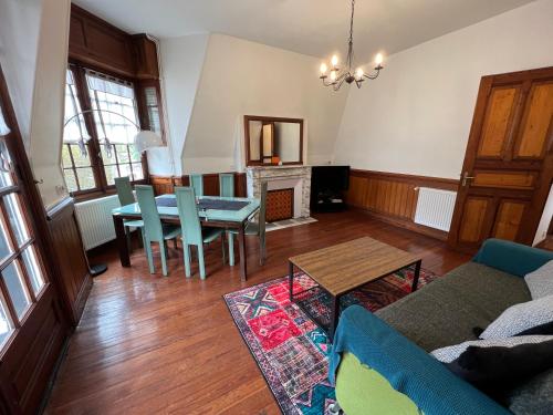 - un salon avec un canapé, une table et une cheminée dans l'établissement Les Grands Ducs, à Trouville-sur-Mer