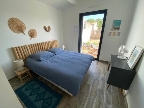 een slaapkamer met een bed met een blauw dekbed bij HOOliRé17 3étoiles in Ars-en-Ré