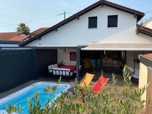 une cour arrière avec une piscine et une maison dans l'établissement Villa à Biarritz avec une terrasse un SPA et parking, à Biarritz