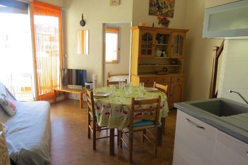 - une cuisine avec une table, des chaises et un évier dans l'établissement Appartement 6 personnes - proche de la plage - Parking - 6FM34B1, au Barcarès