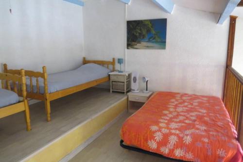 une chambre avec deux lits superposés et une table dans l'établissement Appartement 6 personnes - proche de la plage - Parking - 6FM34B1, au Barcarès