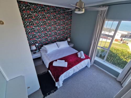 a small bedroom with a bed and a window at BellaBlues in Herolds Bay