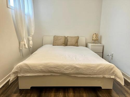 a white bed in a bedroom with a window at Spacious one room in two floors apartment-102 in Montreal