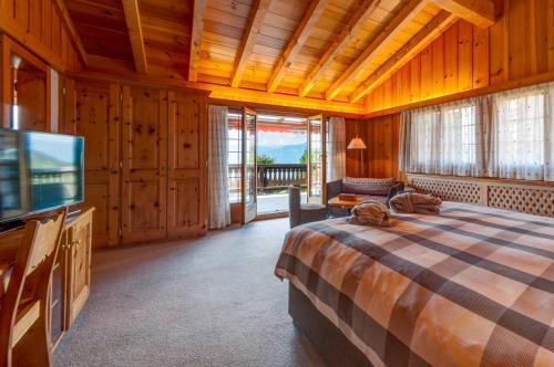 a bedroom with a bed and a flat screen tv at Alpe Fleurie Hôtel & Restaurant in Villars-sur-Ollon
