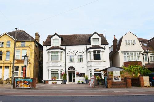 a white building on the corner of a street at Crystal Hotel & Savour in Cambridge