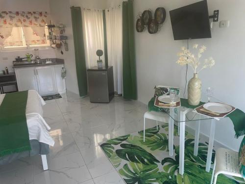 a living room with a table and a kitchen at Royal Terrace V (Duque) in San Felipe de Puerto Plata