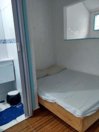 een kleine slaapkamer met een bed en een raam bij Antonia Hospedaria 4 in Búzios