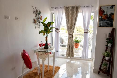 a dining room with a glass table and a window at Royal Terrace V (Duque) in San Felipe de Puerto Plata