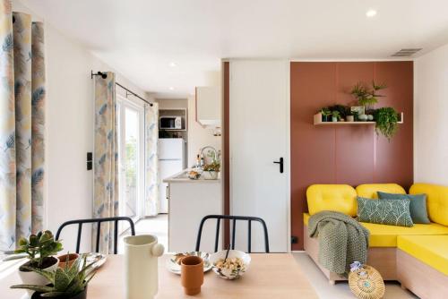een woonkamer met een gele bank en een tafel bij Chalet type F in Voorthuizen