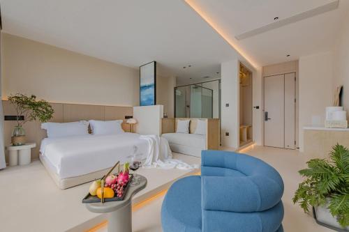 a hotel room with a bed and a blue chair at Dali Oriental Seaview Hotel -Dali Erhai in Dali