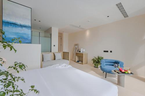 a bedroom with a large bed and a blue chair at Dali Oriental Seaview Hotel -Dali Erhai in Dali