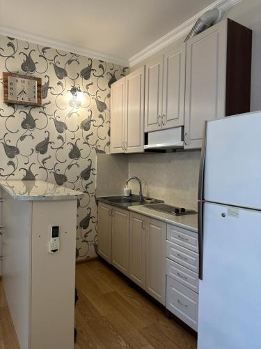 a kitchen with white cabinets and a white refrigerator at Kobaladze Apartments in Batumi