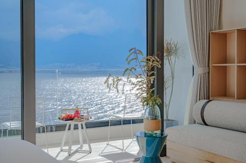 a bedroom with a view of the ocean from a balcony at Dali Oriental Seaview Hotel -Dali Erhai in Dali