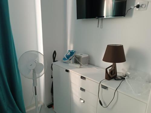 a room with a desk with a lamp and a fan at Mihail apartament in Năvodari