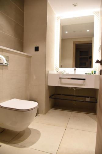 a bathroom with a toilet and a sink and a mirror at Roya Al Andalus Hotel in Al Madinah