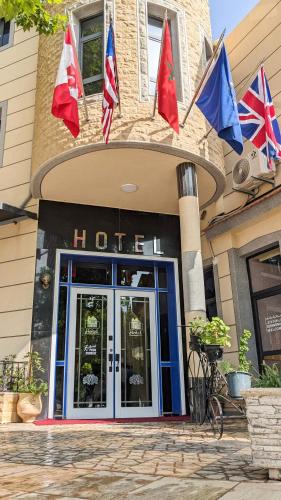 a hotel with flags in front of a building at Hôtel La Chambotte in Imouzzer du Kandar