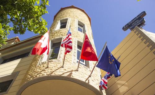 three flags on the side of a building with a street sign at Hôtel La Chambotte in Imouzzer du Kandar
