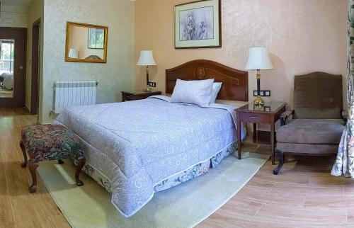 - une chambre avec un grand lit et une chaise dans l'établissement Hôtel La Chambotte, à Imouzzer du Kandar