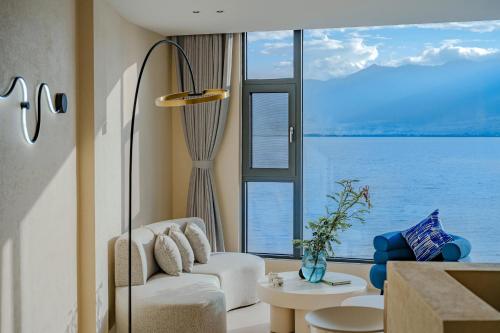 a living room with a white couch and a large window at Dali Oriental Seaview Hotel -Dali Erhai in Dali