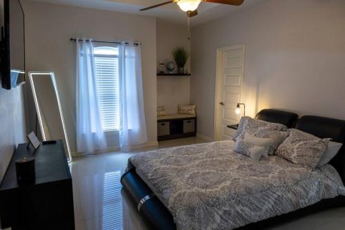 a bedroom with a bed and a table and a window at Cozy home with POOL and free WIFI in Brownsville