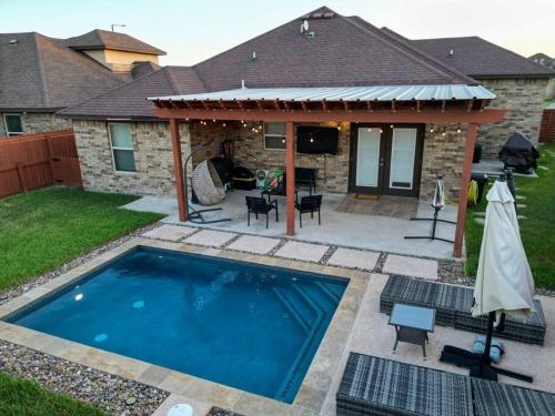a backyard with a swimming pool and a house at Cozy home with POOL and free WIFI in Brownsville
