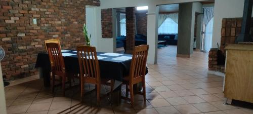 uma sala de jantar com uma mesa preta e quatro cadeiras em Mabel's house em Sabie