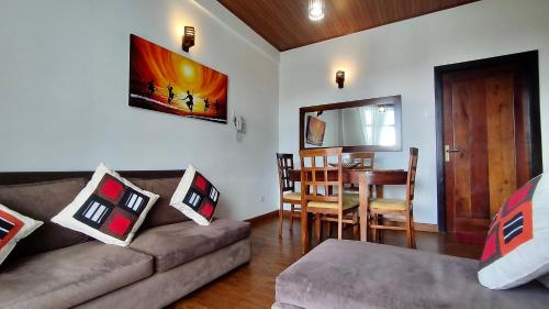 uma sala de estar com um sofá e uma sala de jantar em Skylight Apartment em Nuwara Eliya