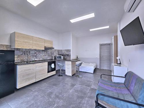 uma cozinha com um sofá e uma cadeira num quarto em La Ca' Pezzana Affittaly Apartments em Bolonha