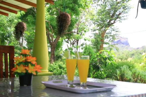 two glasses of beer sitting on a table at Panoramic Royal Villa in Sigiriya